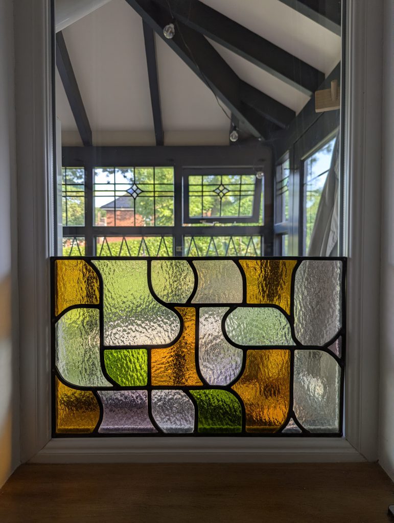 Stained glass abstract pebble window installed