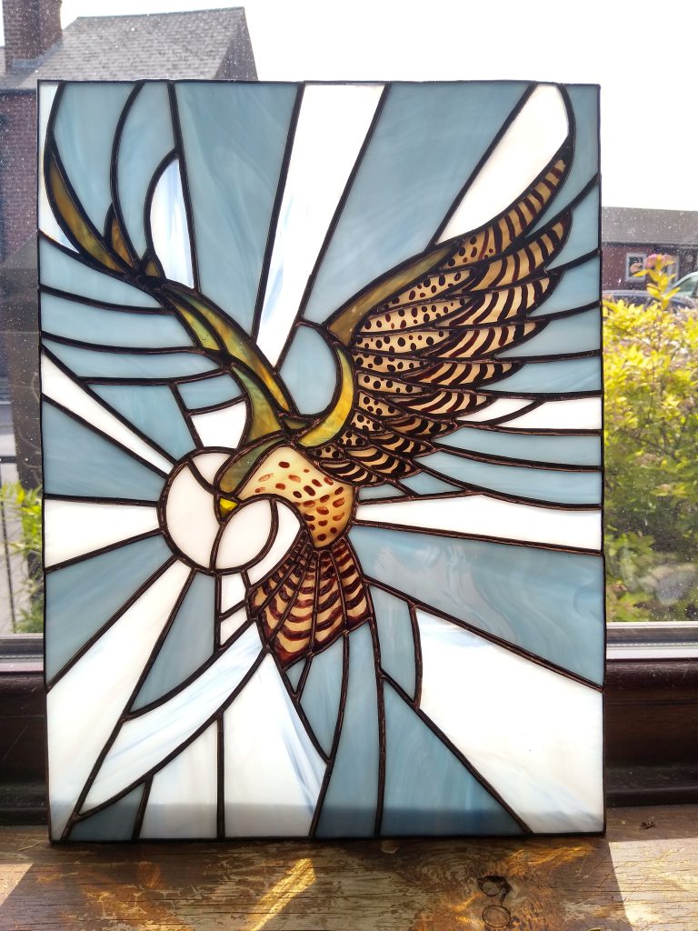 Stained glass sparrowhawk diving panel