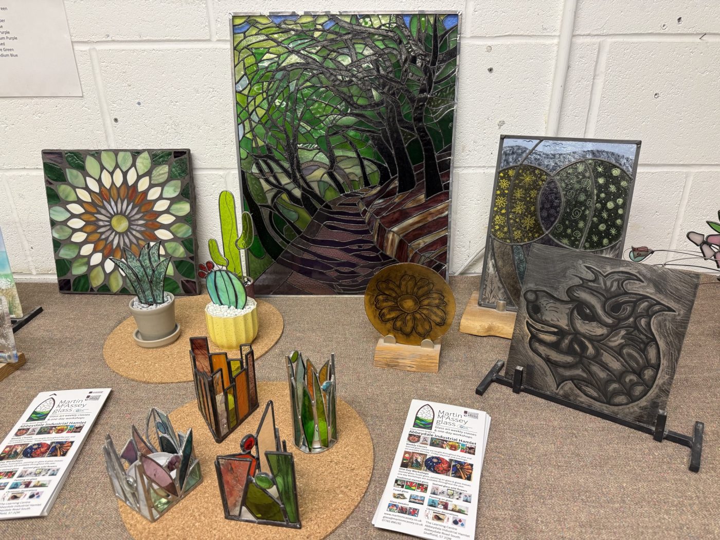 Display of colourful stained glass workshop pieces