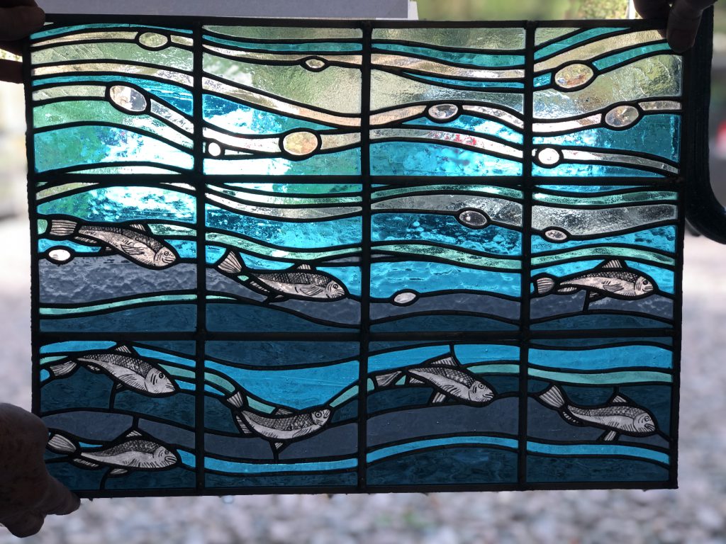 Student stained glass fish shoal painted panel