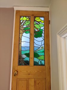 Student stained glass tree panel installed in pine door