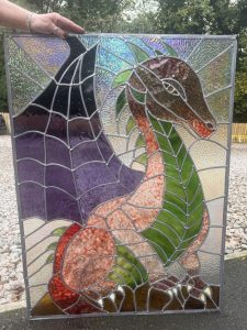 Student stained glass window featuring a purple dragon