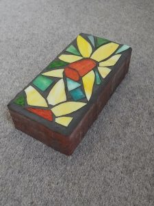 Student-made sunflower mosaic garden block, photographed at an angle