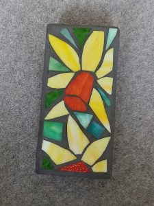 Student-made sunflower mosaic garden block, photographed from above